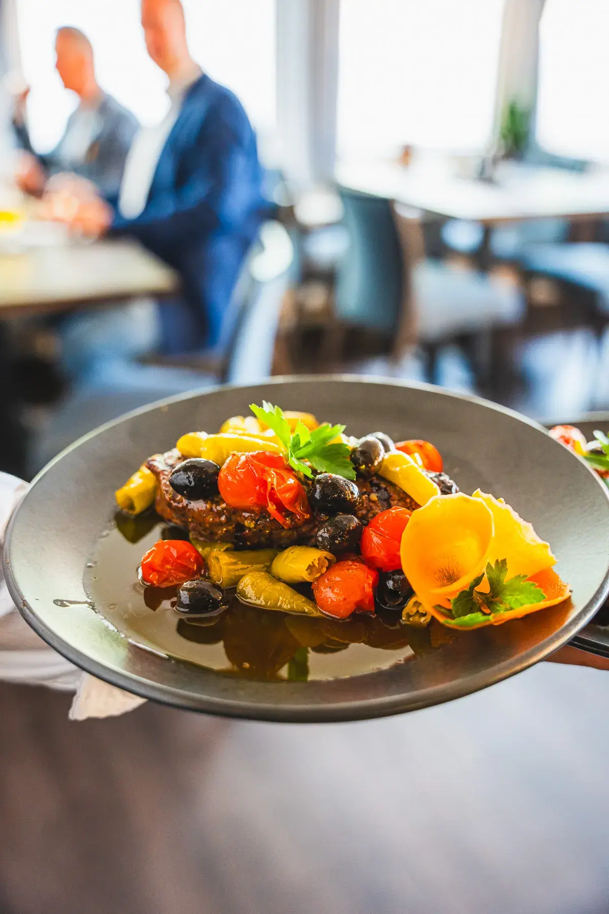 Gemüseteller mit Tomaten, Oliven und Zucchini, im Gastraum serviert