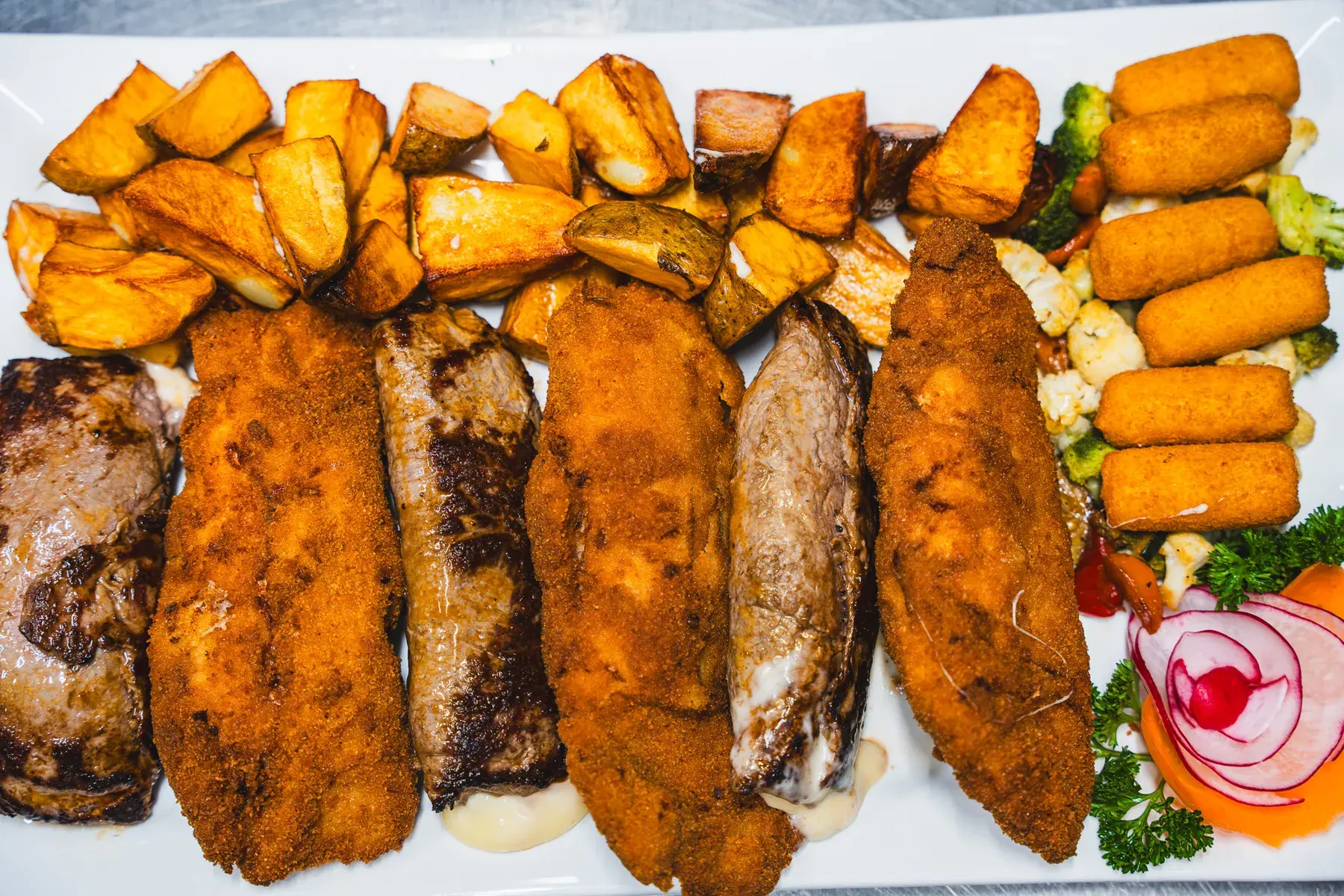Zagreb Schnitzel und Lustiger Bosnier mit Kroketten und Kartoffelspalten, von oben
